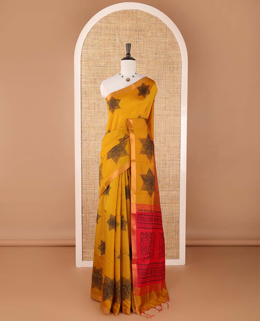 Mustard six-petal-like leaf motifs printed micro-silk saree, copper zari border, contrast intricate pallu & plain red blouse