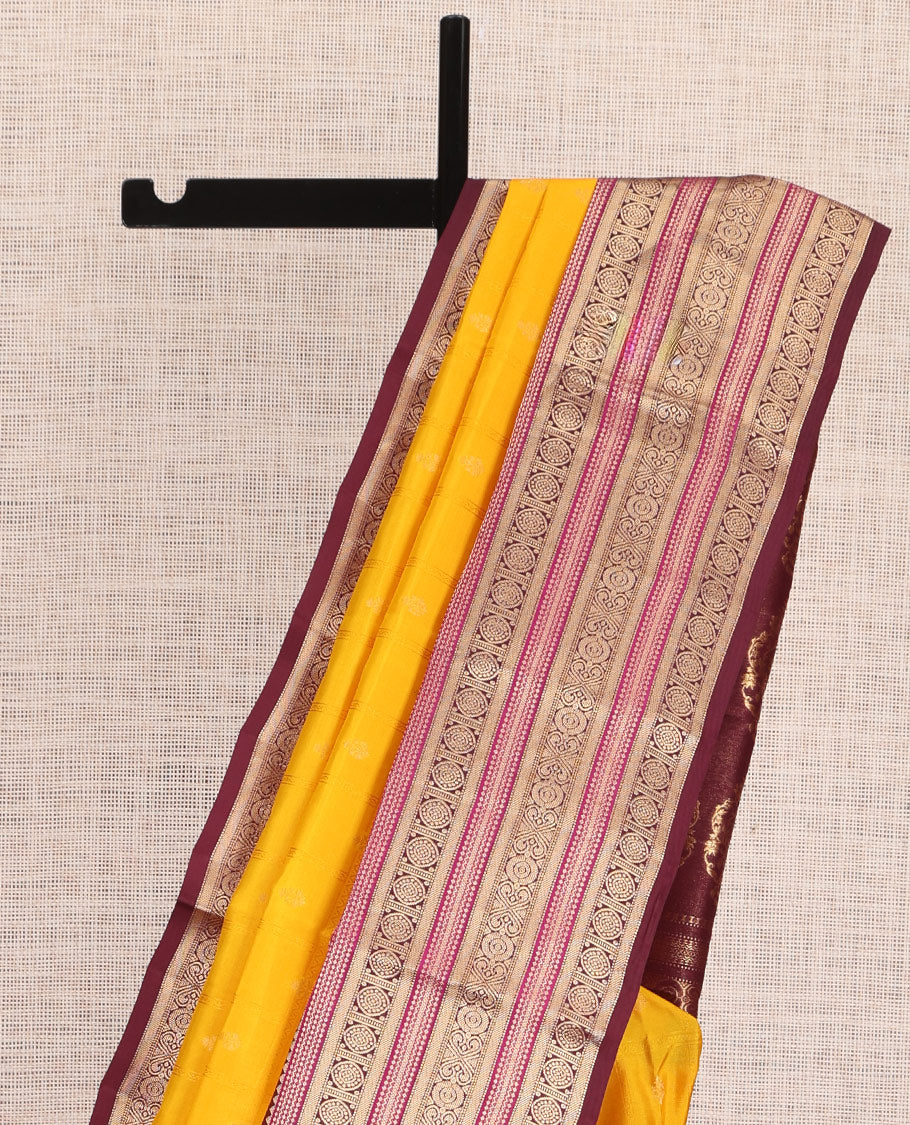 Yellow Vasundhara Silk Saree Subtly Sparkled with Buttas Enclosed Checks All Over Its Body, Complemented by Contrast Border of Rekku, Chakram, and Jada Nagam Designs, a Grandly Woven Pallu of Intricate Mughal Designs, and Paired with a Contrast Blouse