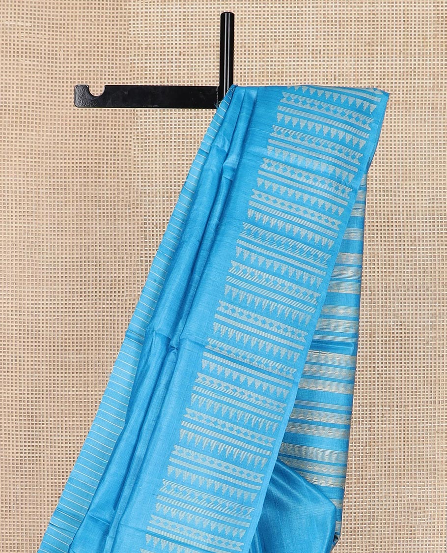 Sky blue plain tussar silk saree, self border and pallu features geometric patterns, and temple motifs