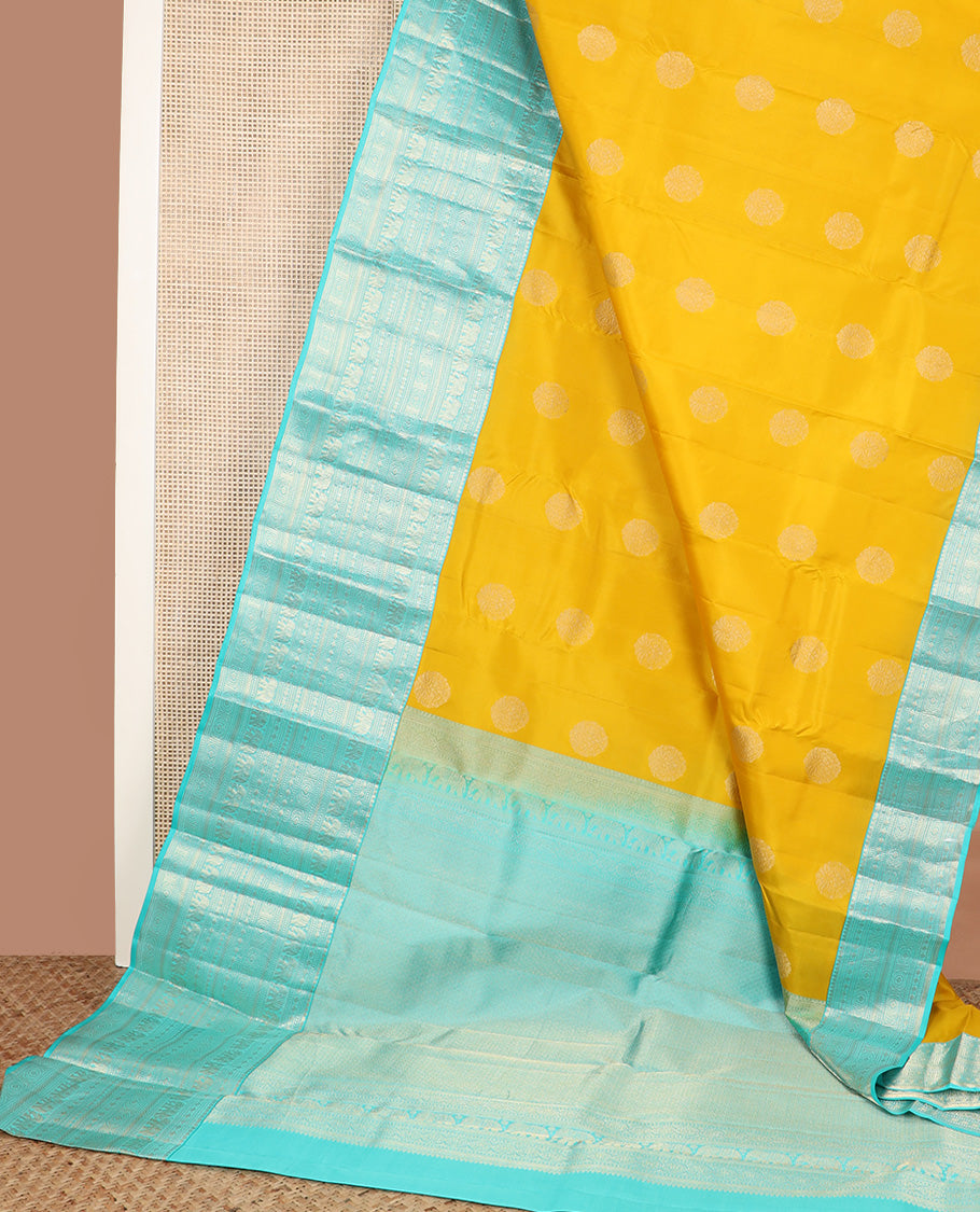 Yellow zari buttas silk saree, contrast border of thilakam mokku, poun, yaanai, chakram, and mayil kann designs, and jaal pallu