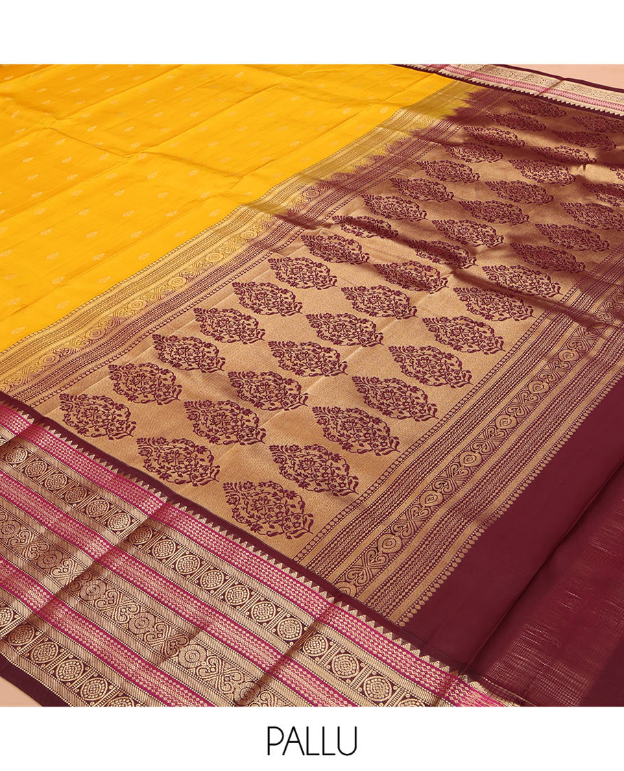 Yellow Vasundhara Silk Saree Subtly Sparkled with Buttas Enclosed Checks All Over Its Body, Complemented by Contrast Border of Rekku, Chakram, and Jada Nagam Designs, a Grandly Woven Pallu of Intricate Mughal Designs, and Paired with a Contrast Blouse