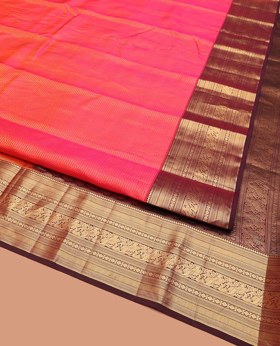 Pink Vasundhara Silk Saree, Beautifully Bedecked with Zari Stripes on Its Body, Complemented by a Contrast Border of Thilakam Mokku, Kathir, Vanki, Mayil, and Laddu Kamalam Designs, Majestically Detailed Jaal Pallu, and Paired with a Contrast Blouse