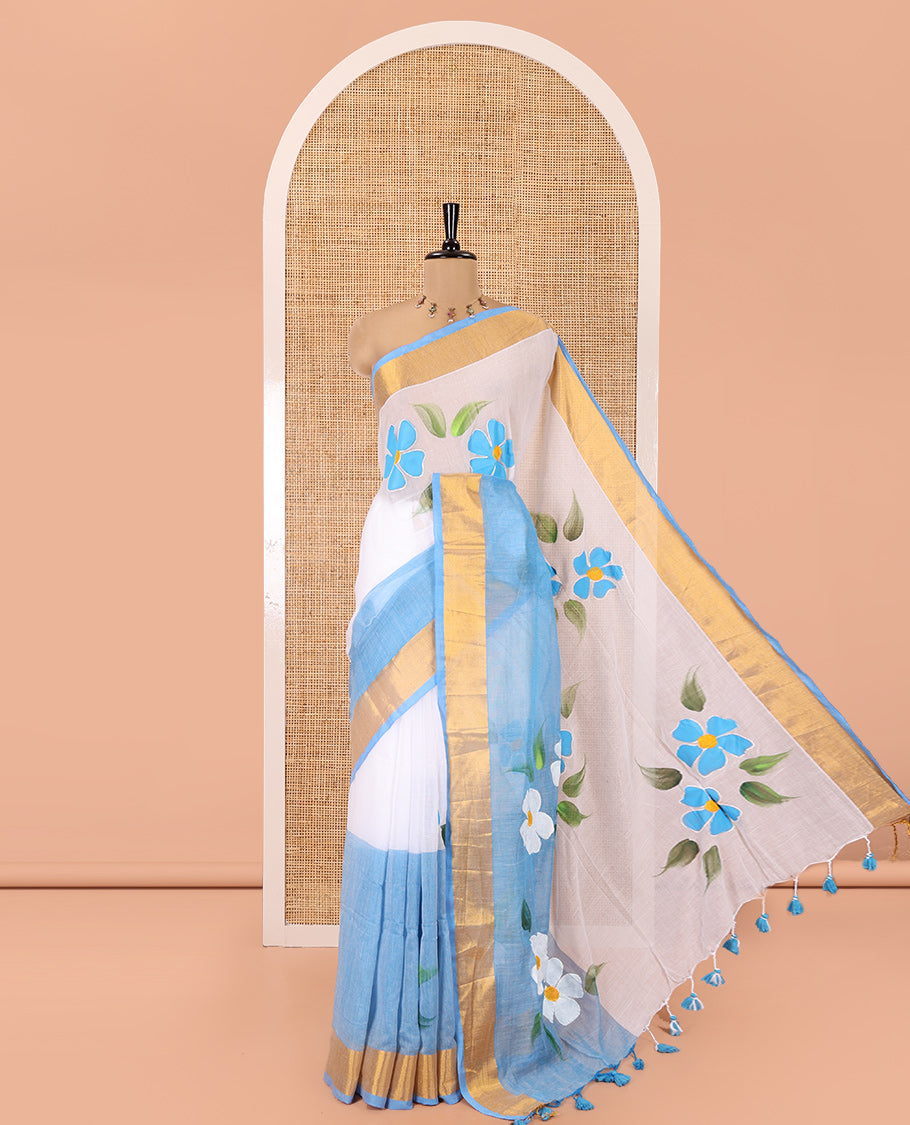 White and Blue Khadi Mul Cotton Saree, Adorned with Hand-Brush Painting-Style Floral Block Printed Body, a Subtle Gold Zari Border, a Self-Pallu, and Paired with a Matching Blouse