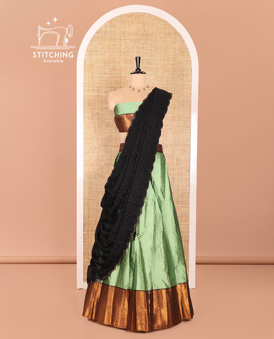 Pista Green Taffeta Silk Half-Saree Featuring a Plain Skirt, Elevated with a Contrast Traditional Zari Design Border, Paired with a Matching Blouse, and a Georgette Scallop-Bordered Stone Work Dhavani
