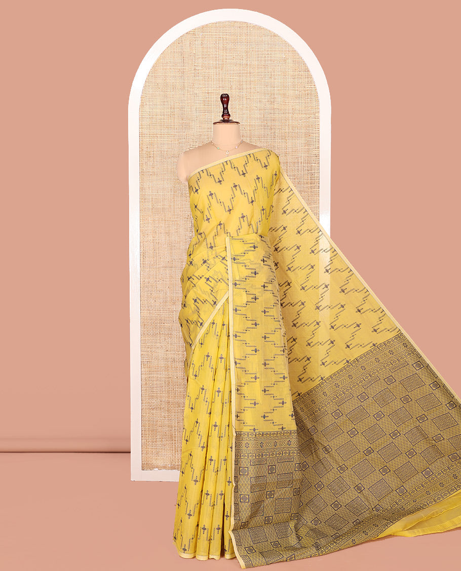 Borderless Yellow Semi-Silk Cotton Saree, Adorned with Unique Buttas on Its Body, Highlighted by Geometric-Patterned Pallu, and Paired with a Matching Blouse