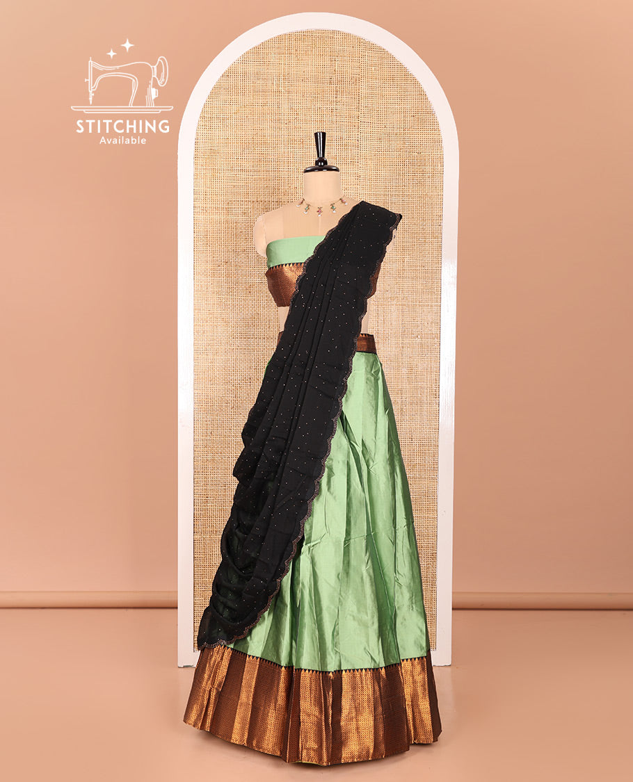 Pista Green Taffeta Silk Half-Saree Featuring a Plain Skirt, Elevated with a Contrast Traditional Zari Design Border, Paired with a Matching Blouse, and a Georgette Scallop-Bordered Stone Work Dhavani
