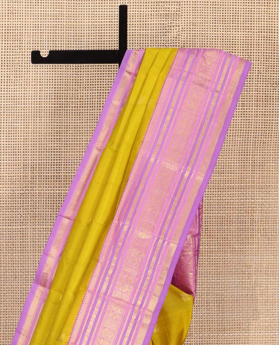 Green Vasundhara Silk Saree, Sparsely Threaded with Zari Buttas All Over Its Body, Complemented by a Contrast Border of Rekku, Muthu, Kathir, Poun, Mayil, and Mayil Kann Designs, Grandly Decked Up Pallu, and Paired with a Contrast Blouse