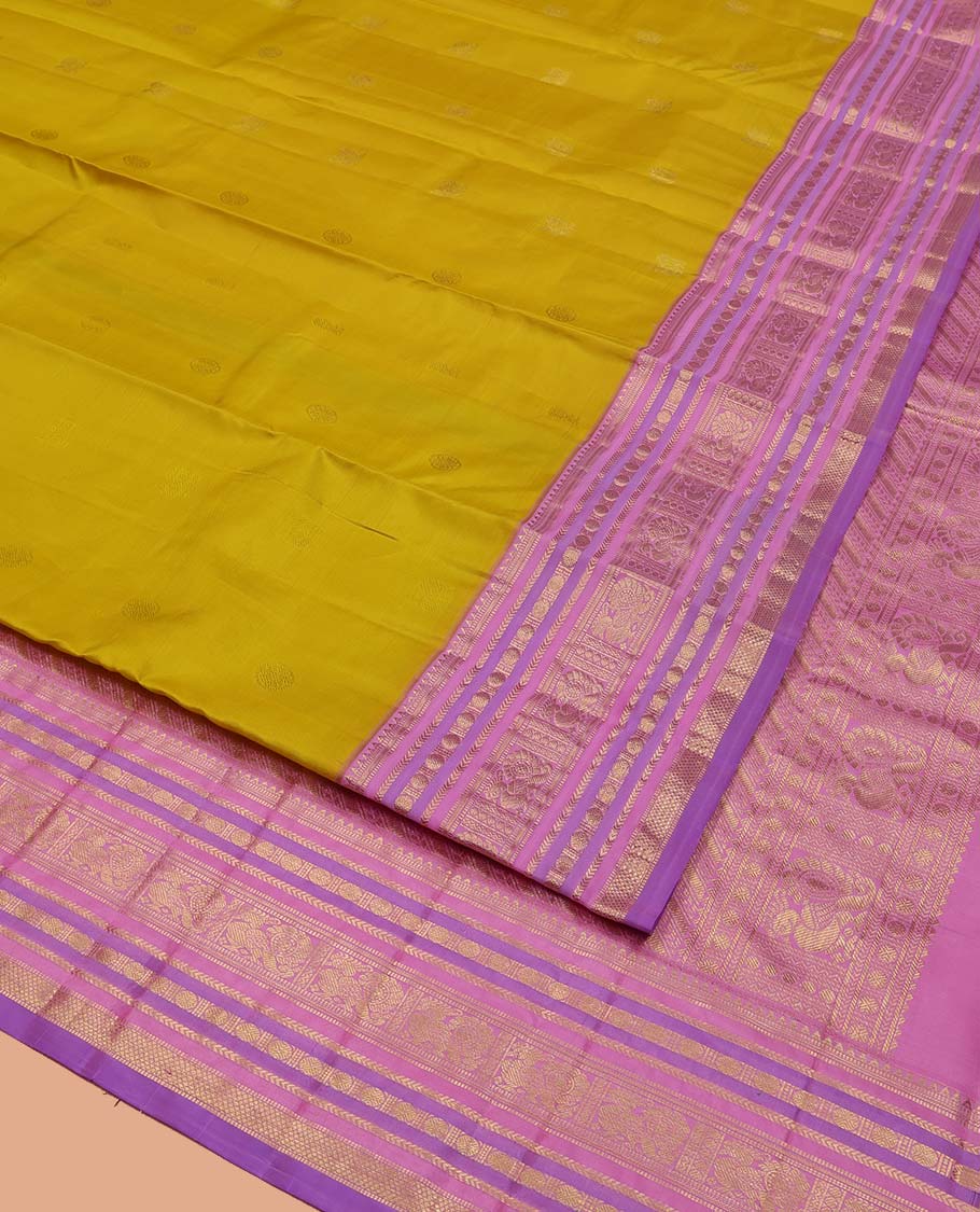 Green Vasundhara Silk Saree, Sparsely Threaded with Zari Buttas All Over Its Body, Complemented by a Contrast Border of Rekku, Muthu, Kathir, Poun, Mayil, and Mayil Kann Designs, Grandly Decked Up Pallu, and Paired with a Contrast Blouse