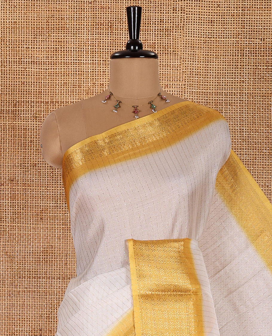 White and Yellow Dola Silk Saree Decked Up with Vertical Zari Stripes All Over the Body, Complemented by a Contrast Border of Traditional Zari Designs, Self-Pallu of Stripes, and Paired with a Contrast Blouse