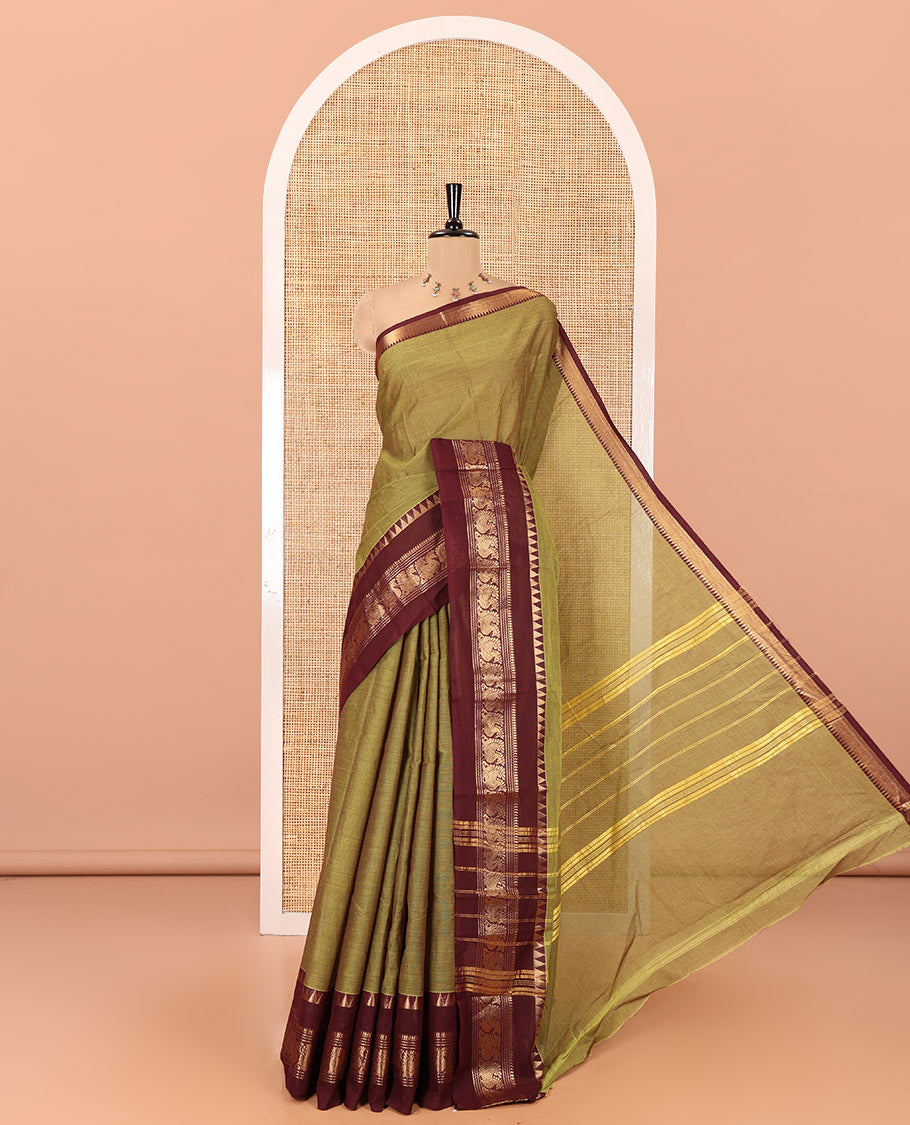 Leaf Green Plain Chettinad Cotton Saree, Complemented by Contrast Rettai Pettu Traditional Zari Border of Temple and Peacock Designs, Striped Pallu, and Paired with a Matching Blouse