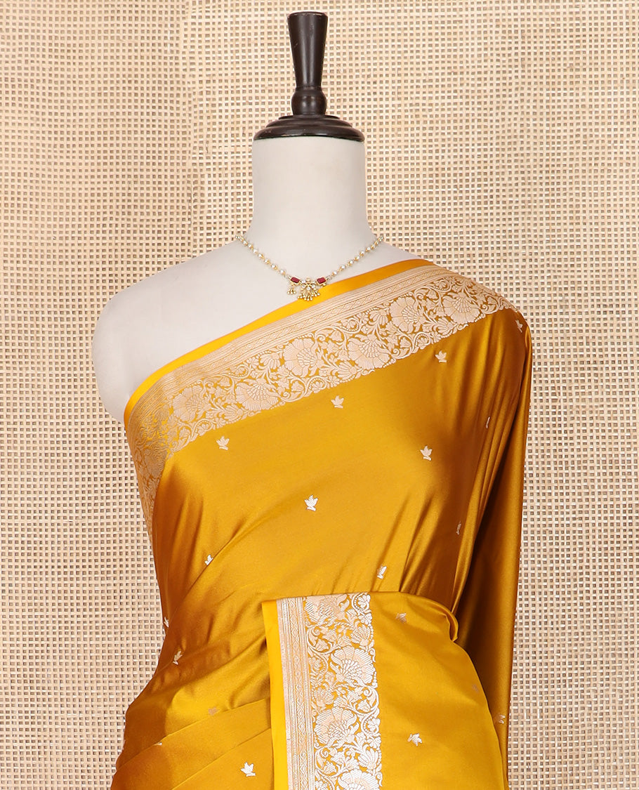 Yellow Semi-Banaras Satin Saree Subtly Sparkled with Zari Buttas, Self-Border Gleamed Up with Floral Creeper Designs, Pallu Creatively Woven of Lotus Motifs, and Paired with a Matching Blouse