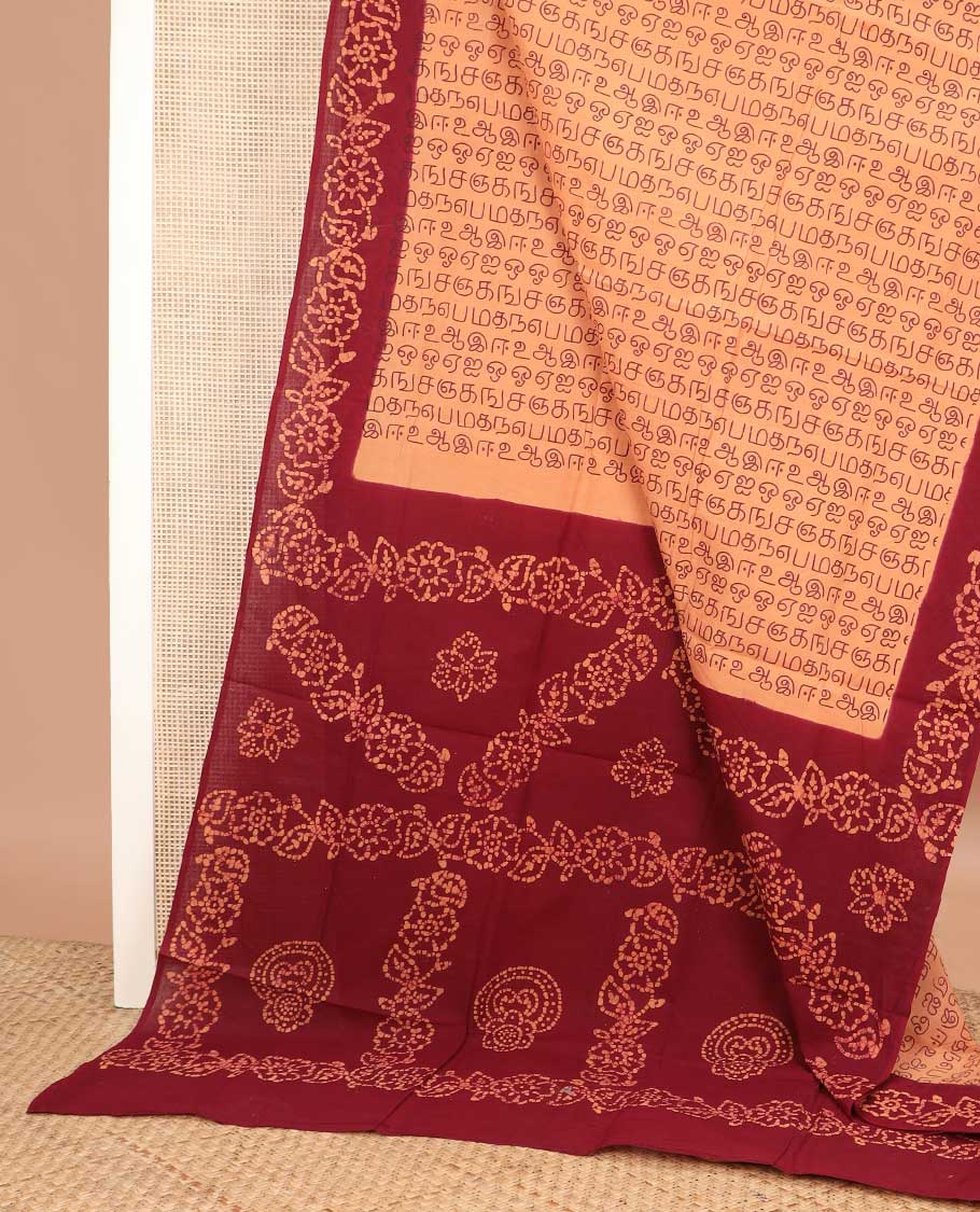 Orange Tamil letters printed sungudi cotton saree, contrast batik printed border, and batik printed pallu