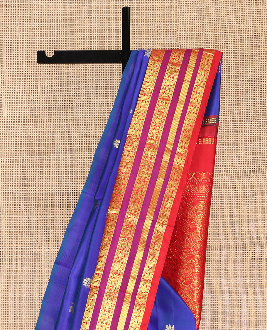 Blue Kanchipuram Silk Saree, Meticulously Crafted with Zari Buttas on Its Body, Complemented by Contrast One-Sided Border of Thilakam Mokku, Neli, Rudraksham, and Mayil Designs, Grandly Woven Pallu of Floral Designs, and Comes Without a Blouse