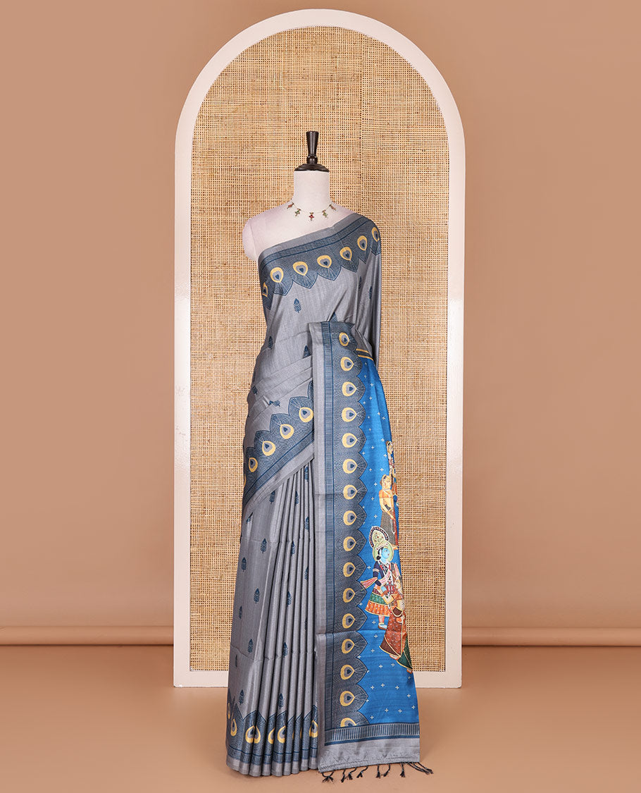 Grey peacock feathers motifs printed katan silk saree, peacock feathers printed border, contrast Radha Krishna stories printed pallu, and contrast printed blouse