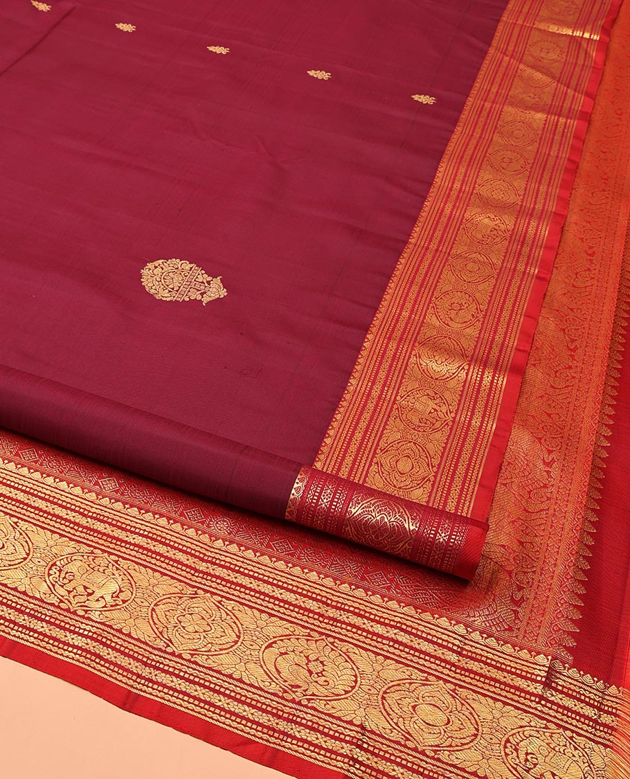 Maroon Kanchipuram Silk Saree, Bedecked with Zari Buttas All Over Its Body, Complemented by a Contrast Border of Neli, Muthu, Cross Kamalam, and Mayil Designs, Pallu of Butta Enclosed Checked Designs, and Paired with a Contrast Blouse