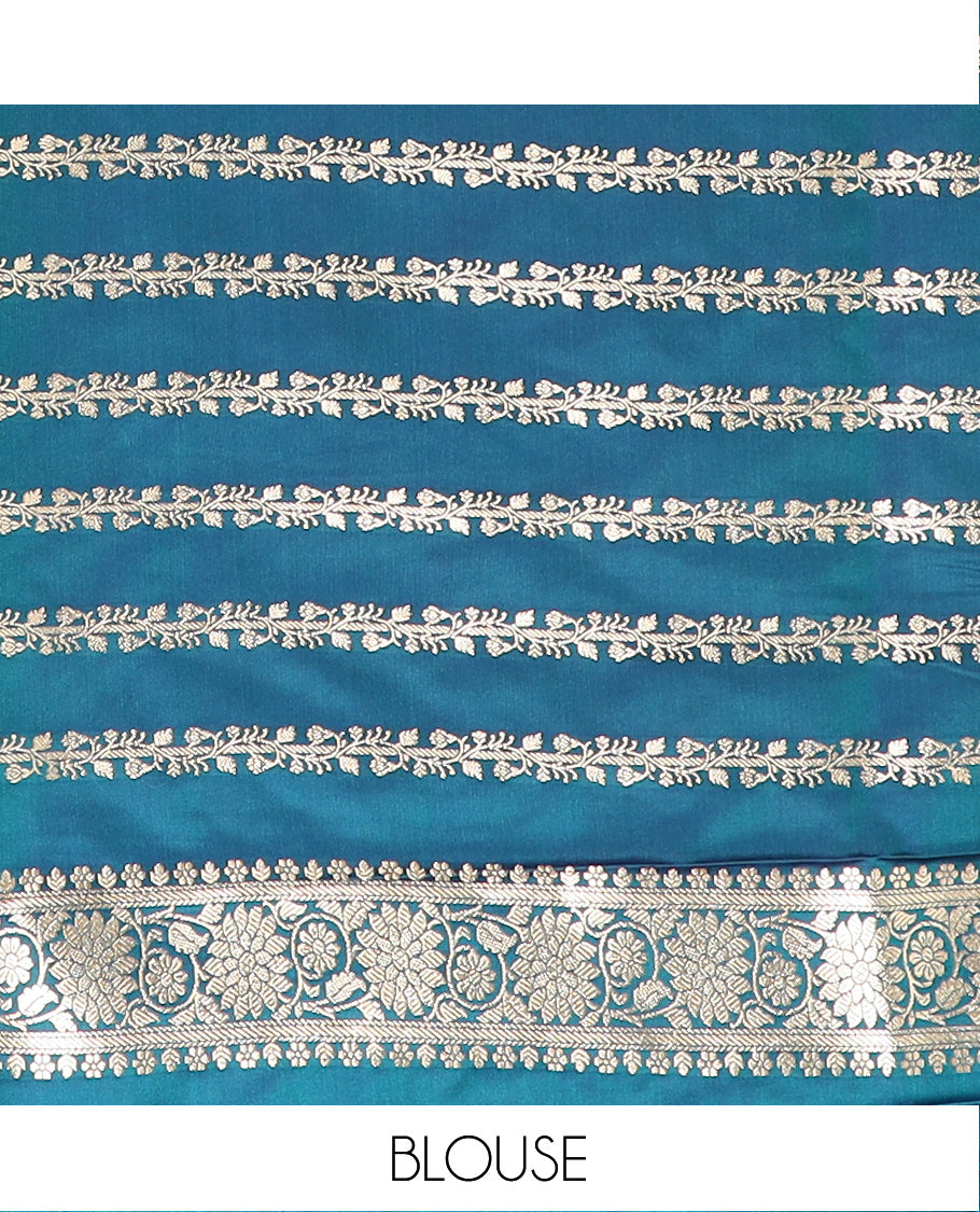Blue Semi-Banaras Satin Saree Subtly Sparkled with Zari Buttas, Self-Border Gleamed Up with Floral Creeper Designs, Pallu Intricately Designed with Mughal-Style Floral Designs, and Paired with a Matching Blouse