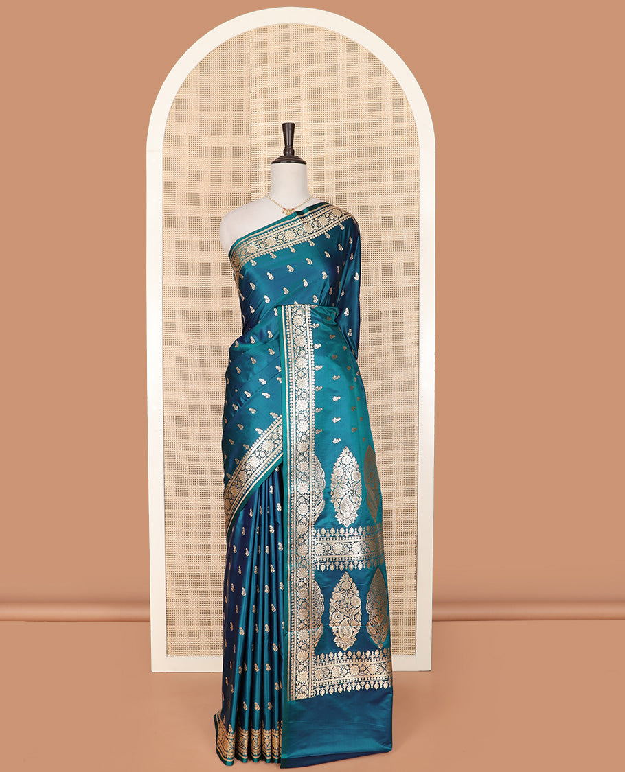 Blue Semi-Banaras Satin Saree Subtly Sparkled with Zari Buttas, Self-Border Gleamed Up with Floral Creeper Designs, Pallu Intricately Designed with Mughal-Style Floral Designs, and Paired with a Matching Blouse
