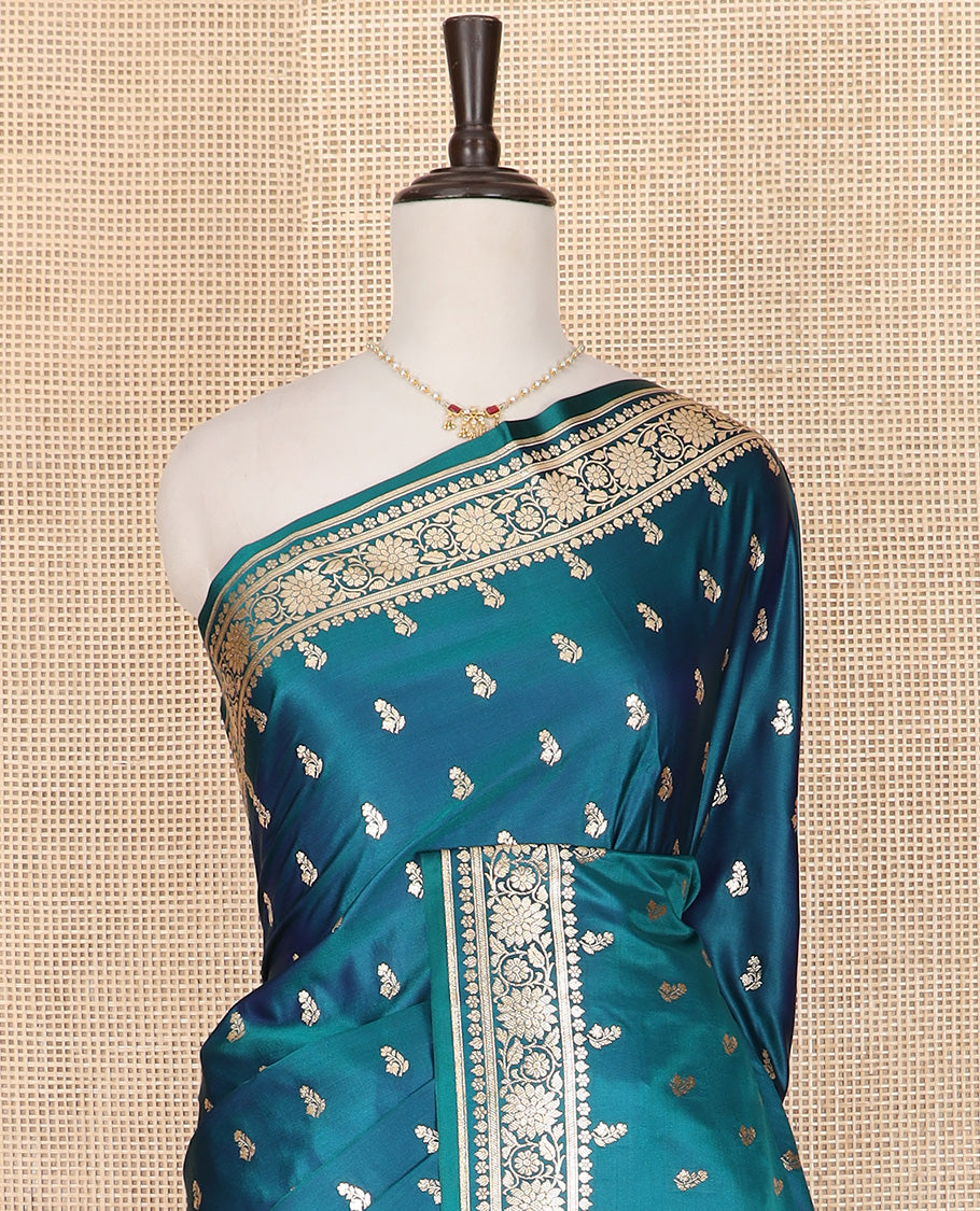 Blue Semi-Banaras Satin Saree Subtly Sparkled with Zari Buttas, Self-Border Gleamed Up with Floral Creeper Designs, Pallu Intricately Designed with Mughal-Style Floral Designs, and Paired with a Matching Blouse