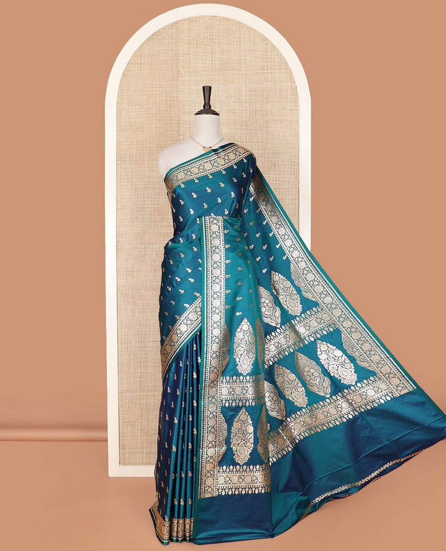 Blue Semi-Banaras Satin Saree Subtly Sparkled with Zari Buttas, Self-Border Gleamed Up with Floral Creeper Designs, Pallu Intricately Designed with Mughal-Style Floral Designs, and Paired with a Matching Blouse