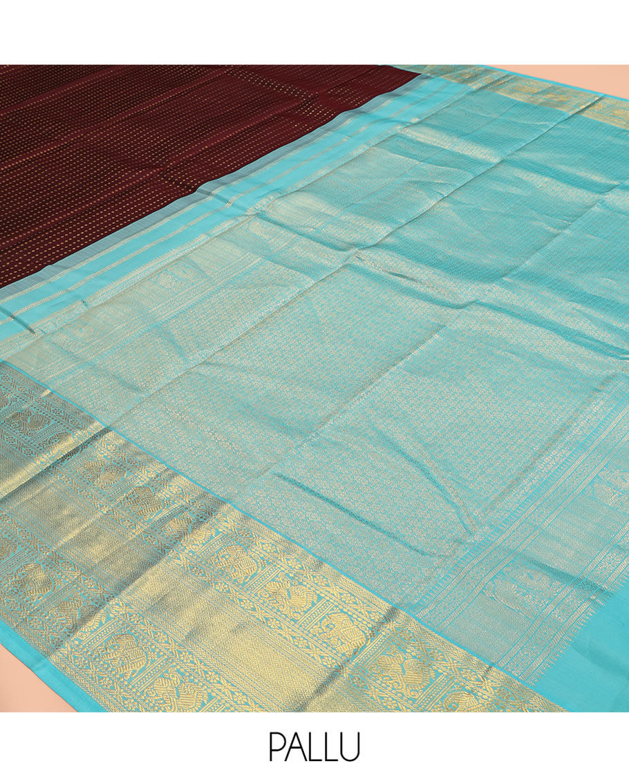 Brown Vasundhara Silk Saree Delicately Woven with Zari Buttas, Highlighted with a Contrast Border of Cross Kamalam, Mayil, Banaras, Yaanai, and Mayil Kann Designs, Pallu Grandly Woven with Jaal Designs, and Paired with a Contrast Blouse