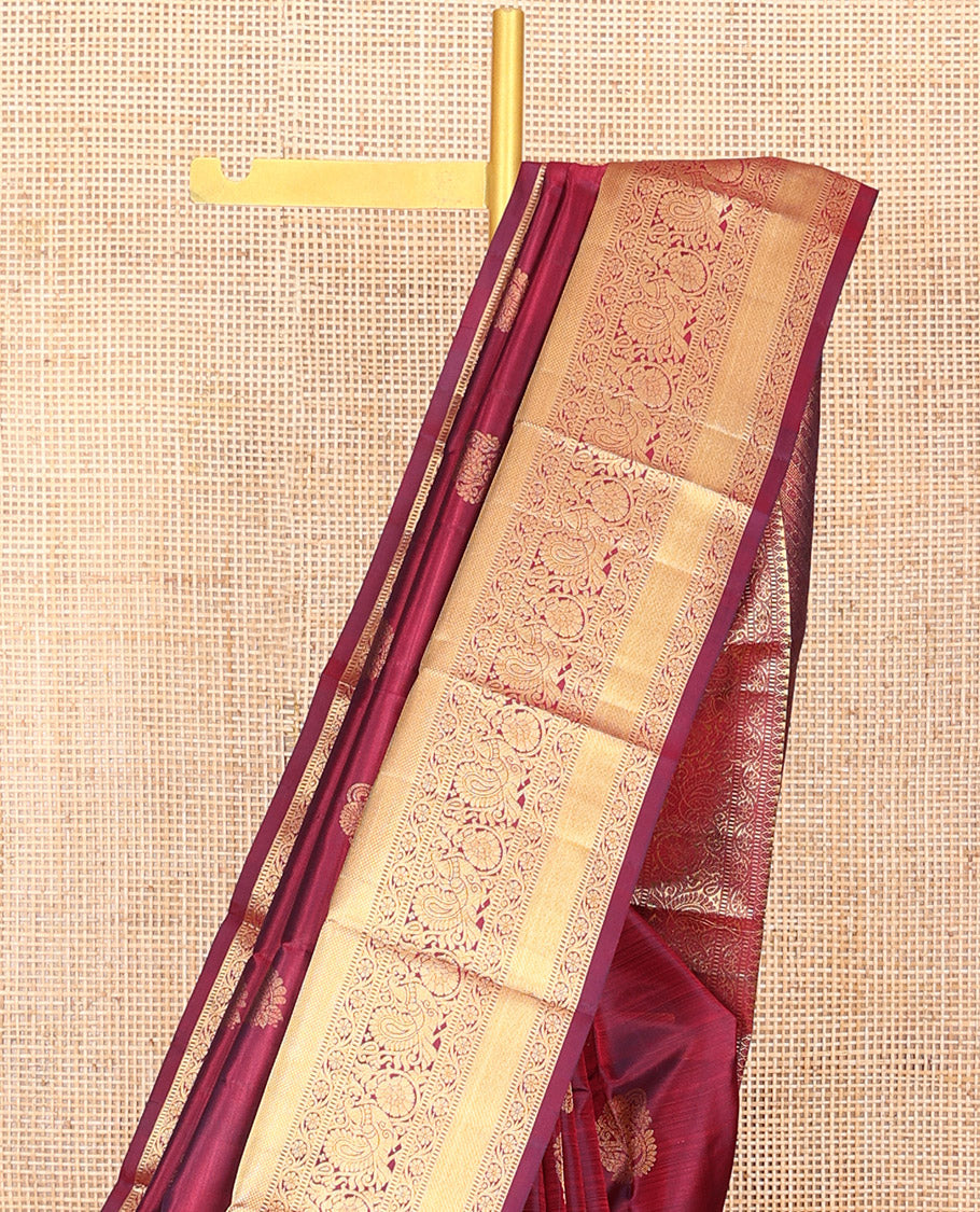Maroon Vasundhara Silk Saree Ornamented with Zari Buttas All Over Its Body, Highlighted by Zari Border of Rekku, Kodi Visiry, Mayil, and Kuyil Kann Designs, a Grand Pallu of Diagonal Stripes, and Paired with a Matching Blouse
