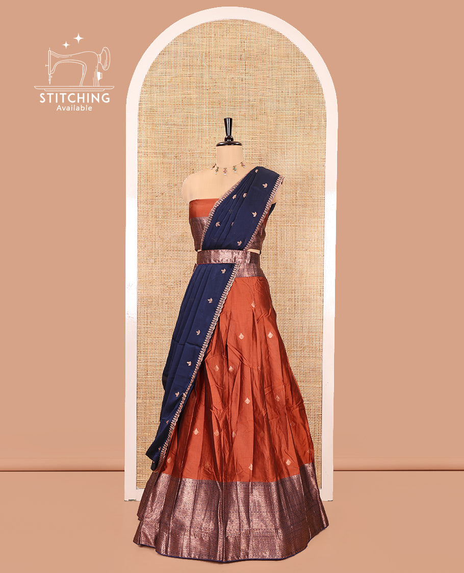 Rust and Navy Blue Semi-Banarasi Half-Saree, Embellished with Zari Buttas on Its Skirt, Complemented by a Contrast Traditional Zari Designs Woven Border, Paired with a Matching Blouse, and a Contrast Satin Georgette Embroidered Scallop Dhavani