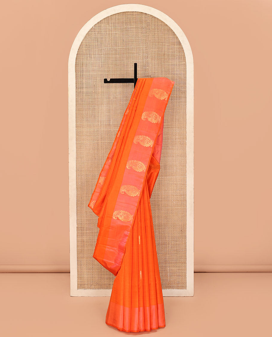 Orange Kanchipuram Silk Saree, Subtly Sparkled with Zari Buttas on Its Body, Complemented by a Contrast Border of Manga Designs, Pallu Steeped with Floral Designs, and Paired with a Contrast Blouse