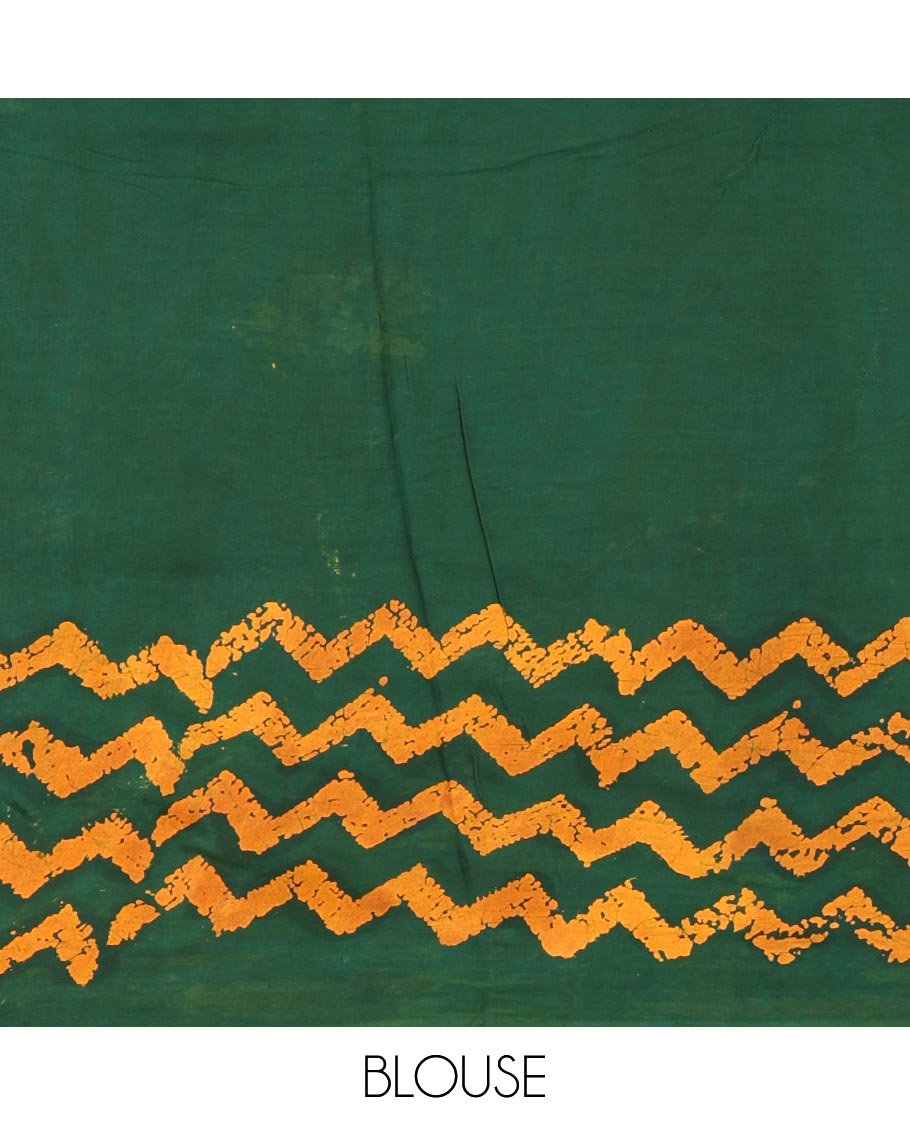 Green wax batik-style zig-zag printed pure cotton saree, gold zari piping border, human figurines batik printed pallu, and a matching blouse