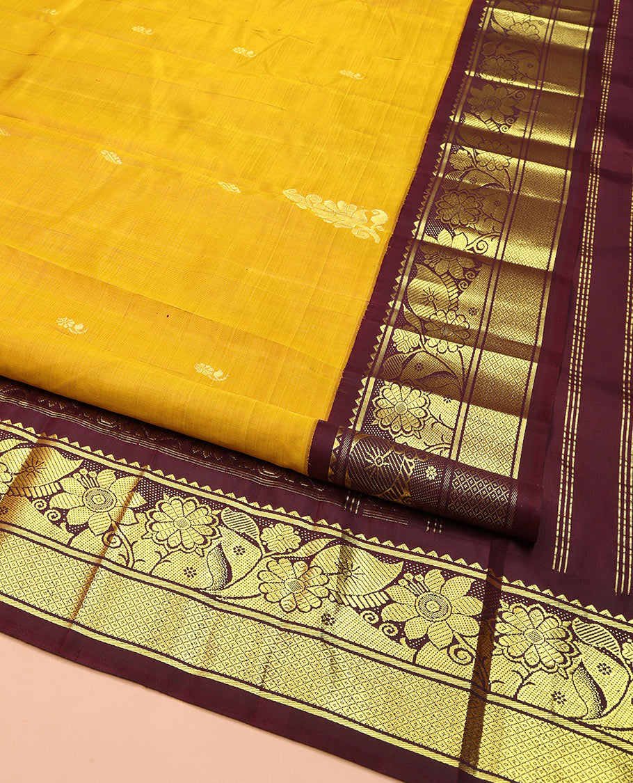 Mustard Kanchipuram Silk Saree, Decorated with Zari Buttas, Complemented by Contrast One-Sided Korvai Border of Rekku, Banaras, Floral and Mayil Kann Designs, Pallu of Floral-Paisley Designs, and Comes Without a Blouse