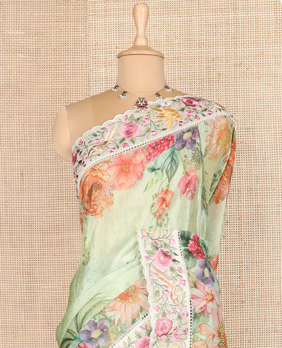 Green Dola Saree Gleamed Up with Gold Buttas and Colorful Tropical Floral Printed All Over Its Body, Complemented by a Contrast Scallop Floral Thread Embroidery Border, Pallu Depicts the Same Body Designs, and Paired with a Contrast Blouse