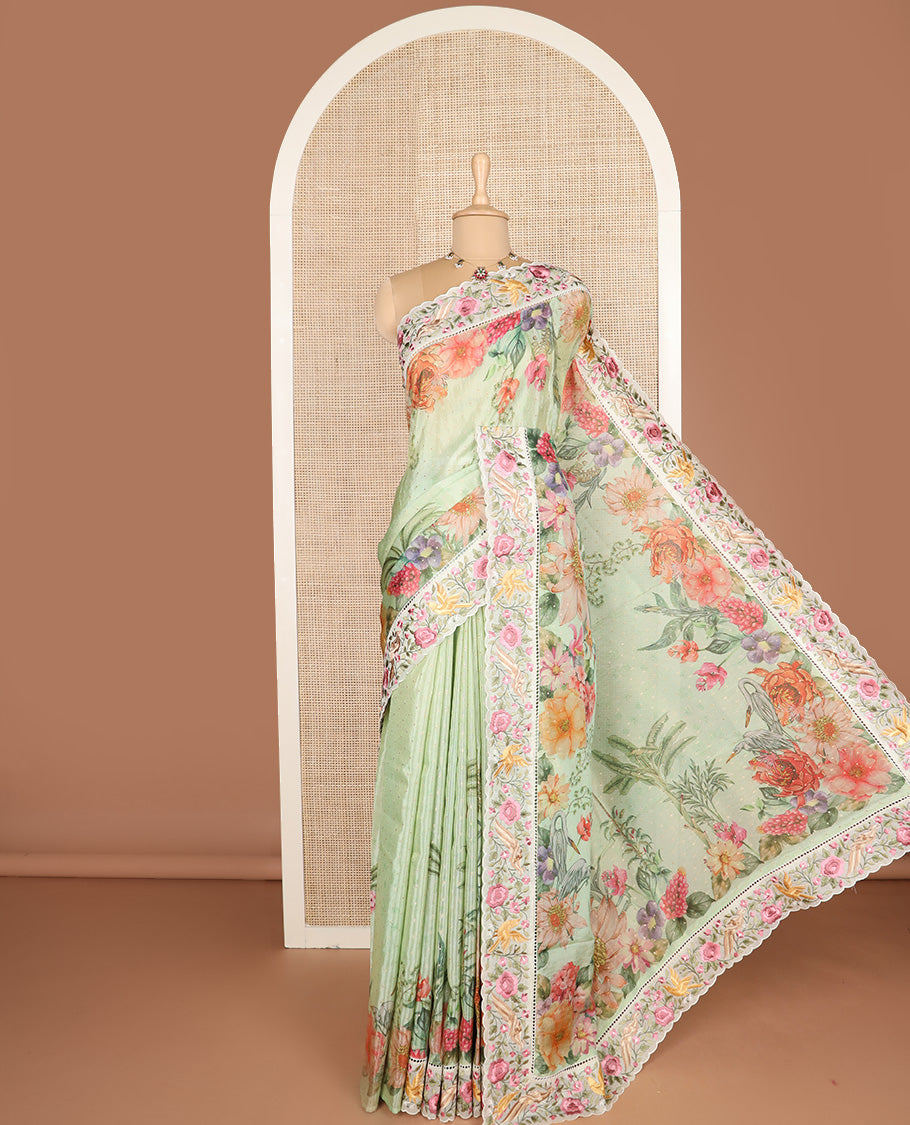 Green Dola Saree Gleamed Up with Gold Buttas and Colorful Tropical Floral Printed All Over Its Body, Complemented by a Contrast Scallop Floral Thread Embroidery Border, Pallu Depicts the Same Body Designs, and Paired with a Contrast Blouse