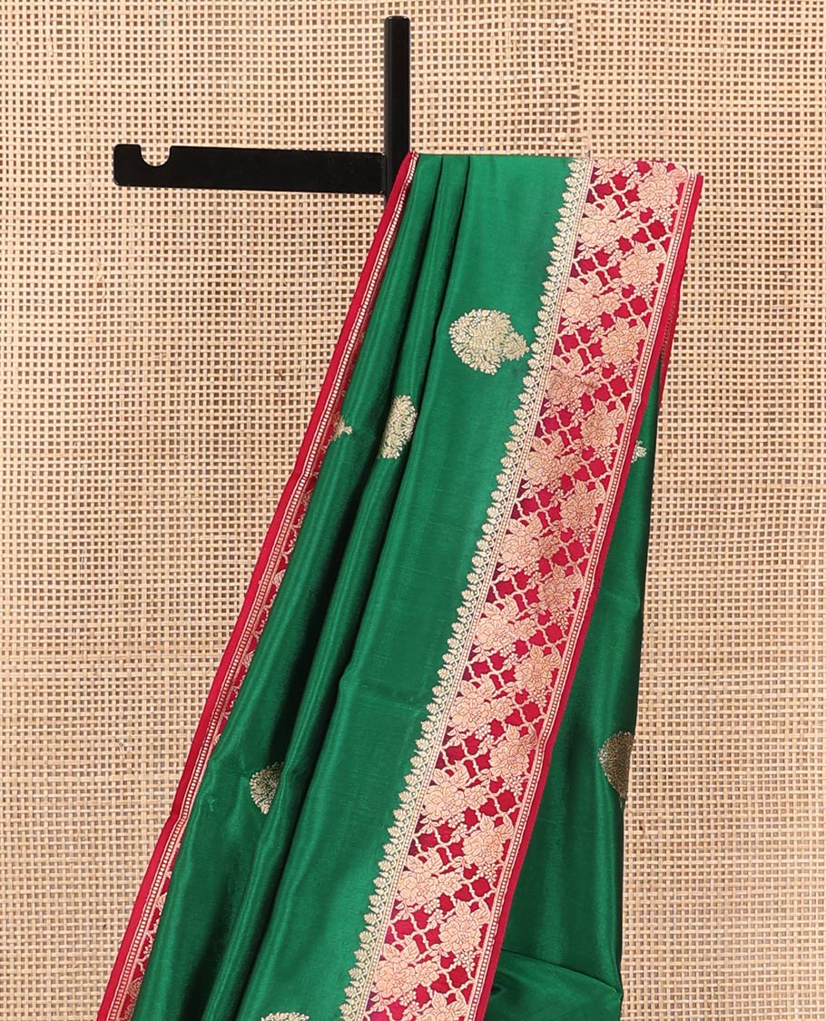 Green Raw Mango Silk Saree Ornamented with Buttas, Complemented by a Contrast Traditional Zari-Design Border, Pallu Depicts Peacock Eye Design, and Paired with a Contrast Blouse