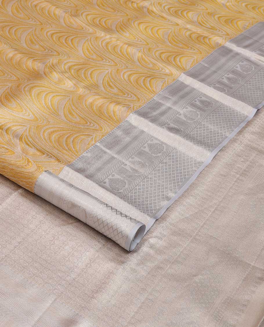 Yellow jacquard Kanchipuram tissue silk saree, contrast border of thilakam mokku, muthu, kathir, puli nagam, and jaal designs, and butta enclosed checks
