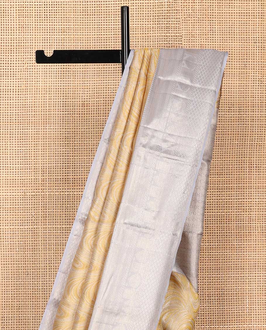 Yellow jacquard Kanchipuram tissue silk saree, contrast border of thilakam mokku, muthu, kathir, puli nagam, and jaal designs, and butta enclosed checks