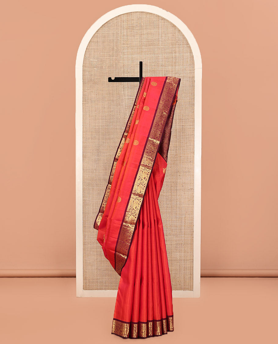 Orange Kanchipuram Silk Saree, Mesmerized with Mayil and Chakram Buttas All Over Its Body, Complemented by Contrast Border of Thilakam, Cross Kamalam, and Yaanai Designs, Pallu Steeped with Rettai Mayil Designs, and Paired with a Contrast Blouse