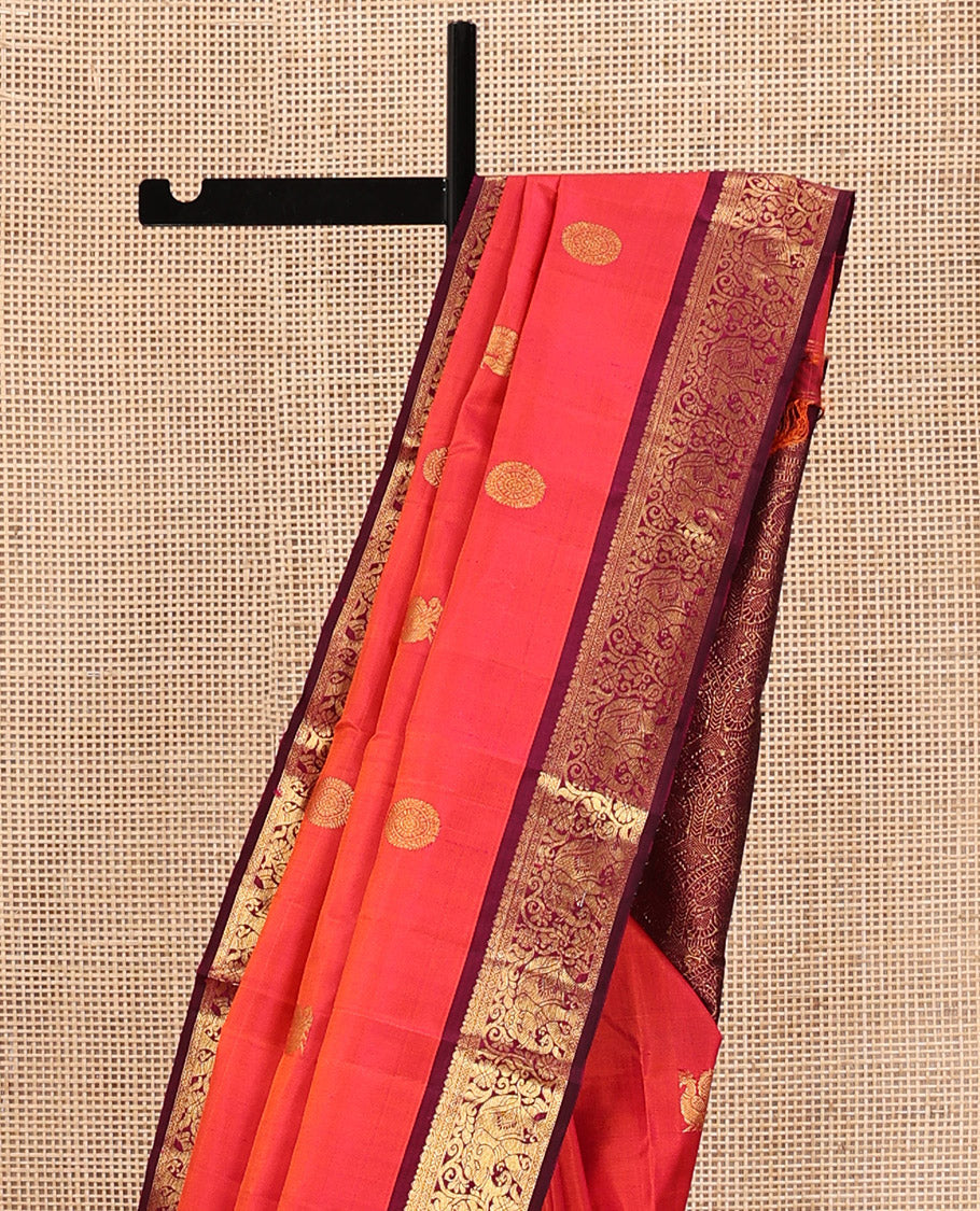 Orange Kanchipuram Silk Saree, Mesmerized with Mayil and Chakram Buttas All Over Its Body, Complemented by Contrast Border of Thilakam, Cross Kamalam, and Yaanai Designs, Pallu Steeped with Rettai Mayil Designs, and Paired with a Contrast Blouse