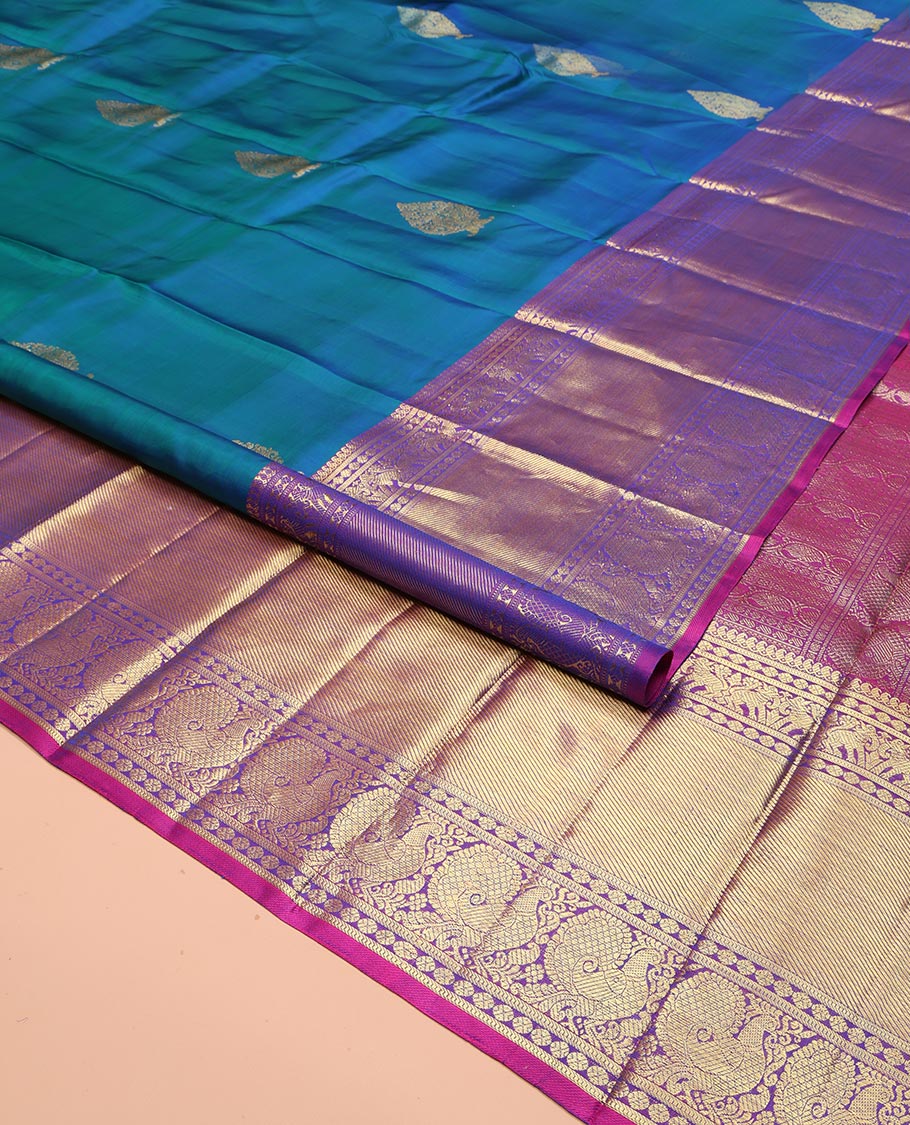 Blue Kanchipuram Silk Saree, Embellished with Zari Buttas All Over Its Body, Complemented by a Contrast Border of Manga Mokku, Poun, Yaali, and Mayil Designs, Pallu of Kodi Visiry Designs, and Paired with a Contrast Blouse