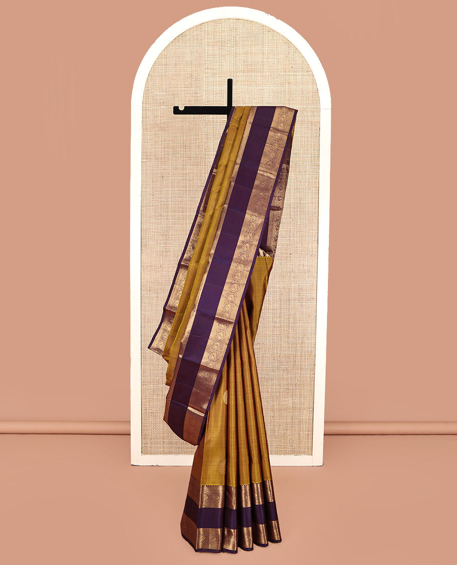Mustard Kanchipuram Silk Saree, Embellished with Round Buttas All Over Its Body, Complemented by a Contrast Rettai Pettu Border of Thilakam Mokku, Muthu, Kathir, and Round Mayil Designs, Grand Jaal Pallu, and Paired with a Contrast Blouse