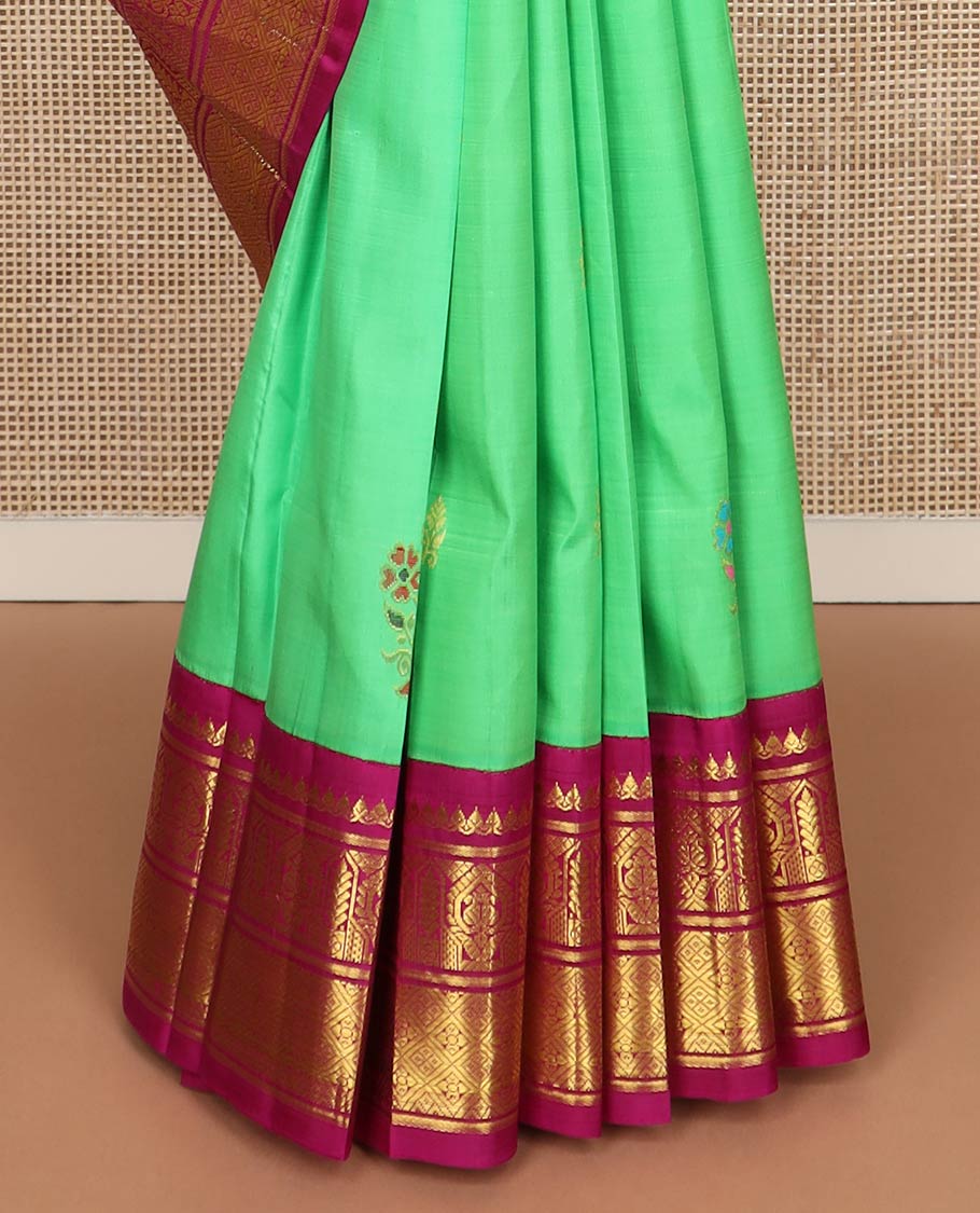 Green floral meena buttas Kanchipuram silksaree, contrast one-sided korvai border of thilakam mokku, manga & jaal & peacock inside palanquin design pallu