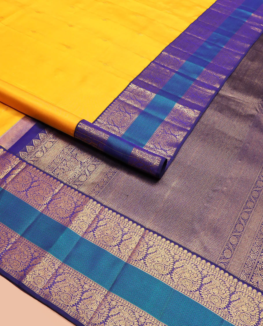 Yellow zari buttas Kanchipuram silk saree, contrast border of salangai, manga, muthu, arumbu manga, and mayil kann designs, and vanki pallu