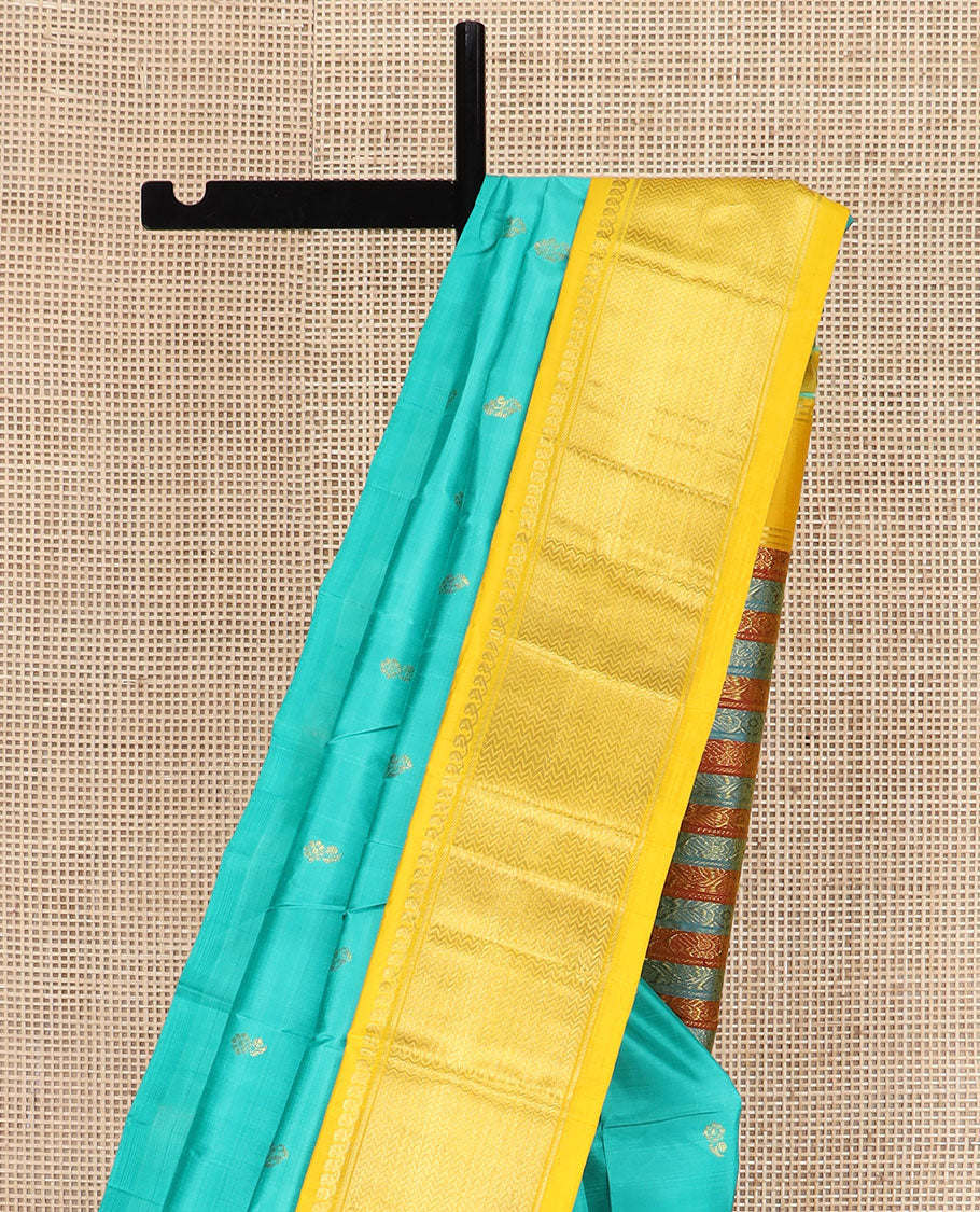 Turquoise Kanchipuram Silk Saree Prettified with Zari Buttas All Over Its Body, Complemented by Contrast One-Sided Korvai Border of Manga Mokku, and Vanki Designs, Pallu Steeped with Floral-Paisley Designs, and Comes Without a Blouse