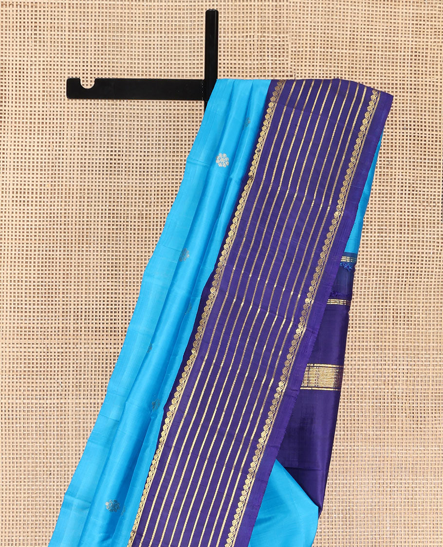 Blue Kanchipuram Silk Saree, Embellished with Zari Buttas, Complemented by Contrast One-Sided Korvai Border of Thilakam Mokku and Banaras Designs, Pallu Steeped with Floral Designs, and Comes Without a Blouse