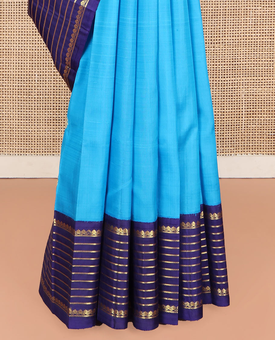 Blue Kanchipuram Silk Saree, Embellished with Zari Buttas, Complemented by Contrast One-Sided Korvai Border of Thilakam Mokku and Banaras Designs, Pallu Steeped with Floral Designs, and Comes Without a Blouse