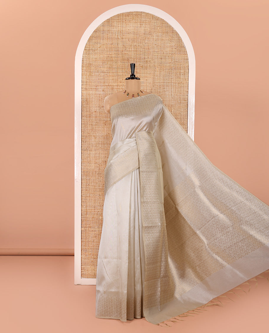 Cream Semi Tussar Saree Enriched with Zari Floral Buttas, Gleaming Zari Design Border, Majestically Detailed Pallu in Zari, and Paired with a Matching Blouse