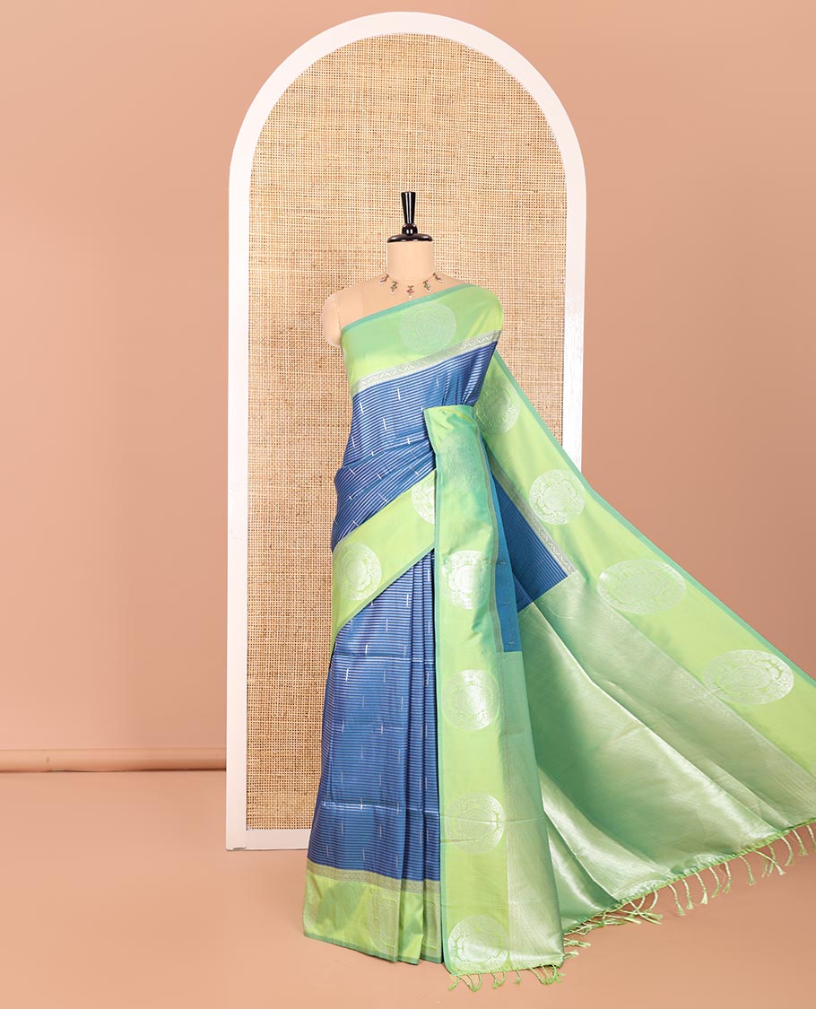 Petrol Blue Elite Soft Silk Saree Ornamented with Vaira Oosi and Zari Buttas All Over Its Body, Complemented by a Contrast Border Featuring Chakram Motifs, Subtly Sparkled Pallu, and Paired with a Contrast Blouse