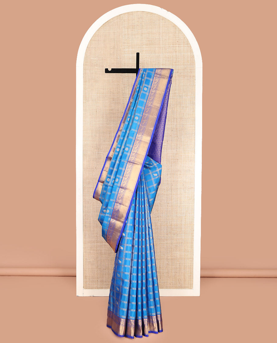 Blue Vasundhara Lite-Silk Mix Saree, Spotlighted with Yaanai, and Chakram Butta Enclosed Checks, Complemented by a Contrast Border of Thilakam, Poun, and Mayil Designs, Pallu Highlighted by Geometric Designs, and Paired with a Contrast Blouse