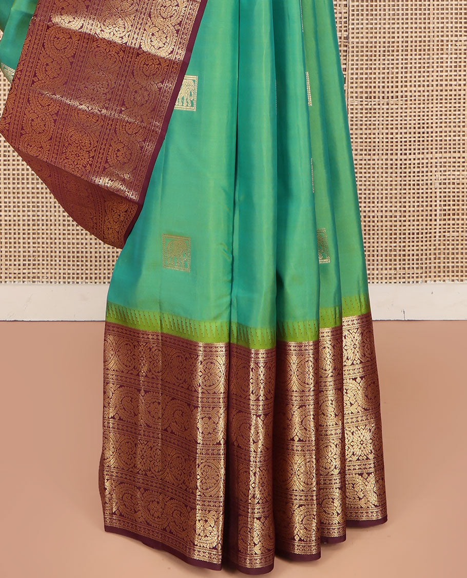 Sea Green Vasundhara Silk Saree, Accentuated with Zari Buttas All Over Its Body, Complemented by Contrast Border of Ara Bogudi, Banaras, Jada Nagam and Dhavana Kodi Designs, Pallu of Intricate Designs, and Paired with a Contrast Blouse