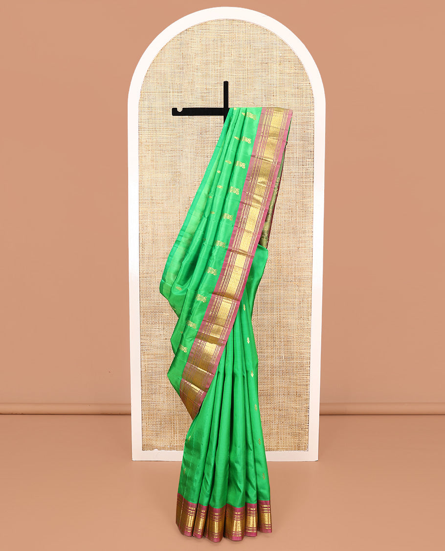 Green Kanchipuram Silk Saree, Adorned with Zari Buttas All Over Its Body, Complemented by a Contrast One-Sided Border of Panner Sombu, Banaras, Muthu, and Jaal Designs, Pallu of Floral Paisleys, and Comes Without a Blouse