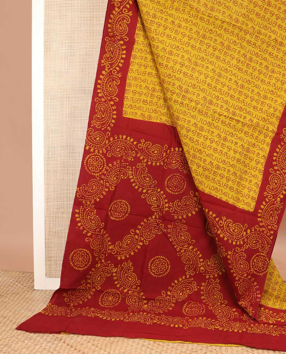 Yellow Tamil letters printed sungudi cotton saree, contrast batik printed border, and batik printed pallu