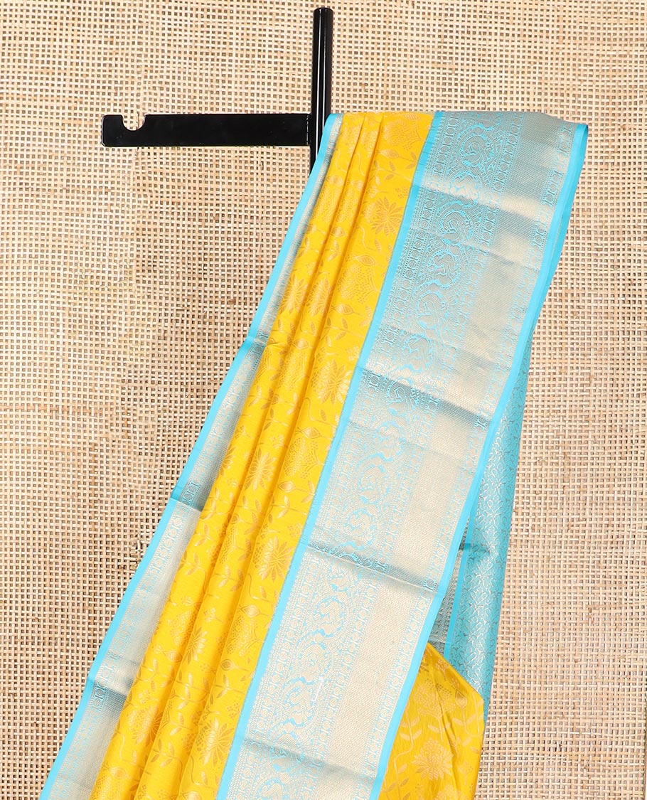 Yellow floral design kancheepuram silk saree with contrast border of thilakam mokku, banaras, muthu, paun design & zari design pallu